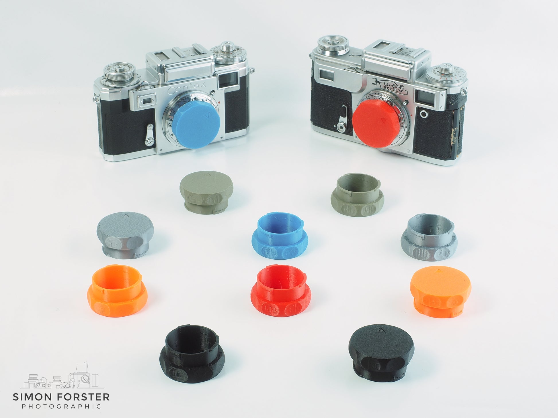 Body caps for contax and keiv are being displayed on a white background. The body caps have been designed by forster uk and sold on simonforsterphotographic.co.uk. The caps are being showcased in six different colours, ranging from black, orange, red, mid blue, silver and survival green.