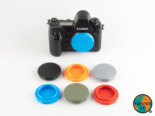 Camera with colourful body caps on a white background